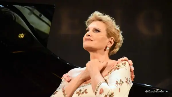 La reconocida soprano Ainhoa Arteta en el escenario, cantando con pasión, acompañada por un pianista.