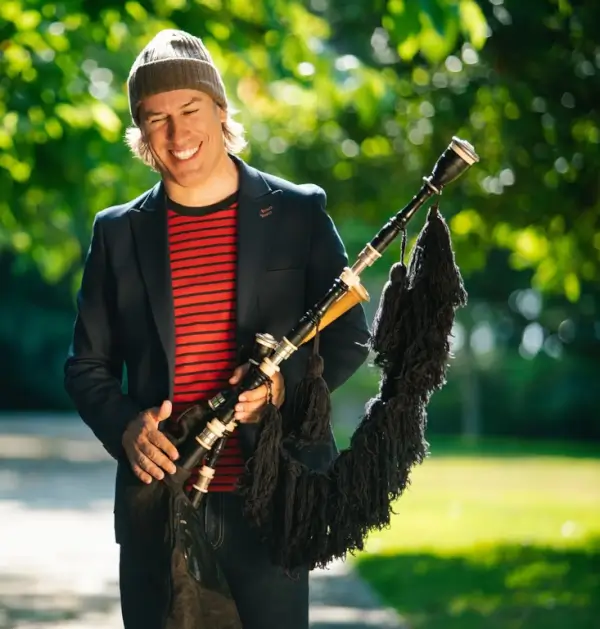 Carlos Núñez tocando la gaita en un escenario.