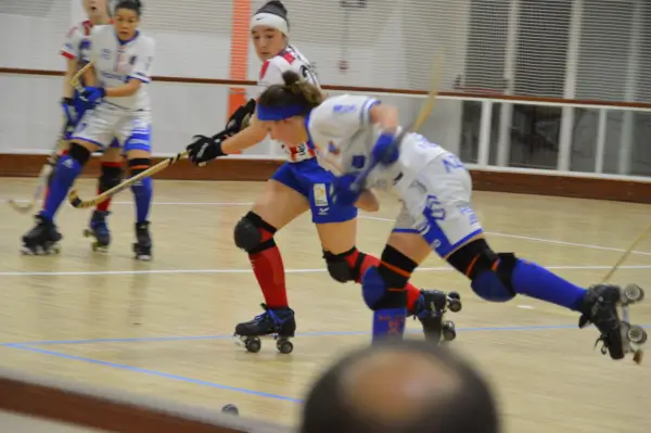 Jugadoras de hockey sobre patines en acción durante un partido, con el stick y la bola en movimiento.