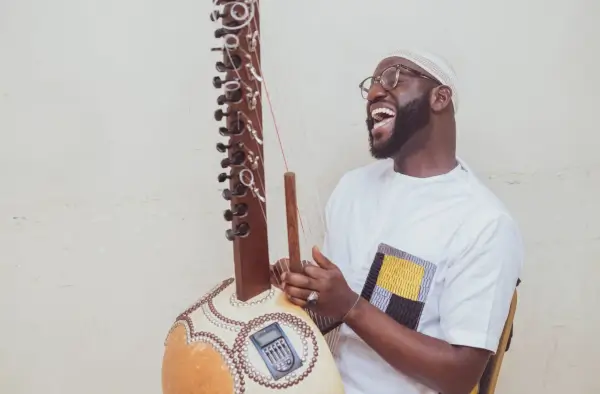 Seckou Keita tocando la kora en el escenario junto a la Real Filharmonía de Galicia, con el director Clark Rundell.