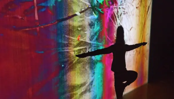 Personas practicando yoga en una sala de exposiciones de arte.