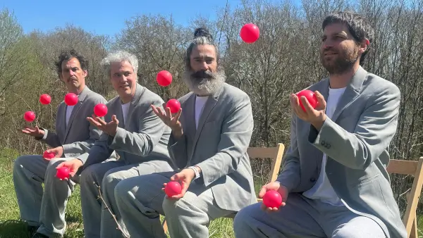 Tres malabaristas en escena con objetos volando, creando un ambiente de caos divertido y competencia en un espectáculo de circo.