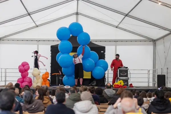 El payaso Lolo de Barafunda haciendo figuras con globos, con una expresión divertida y rodeado de niños.