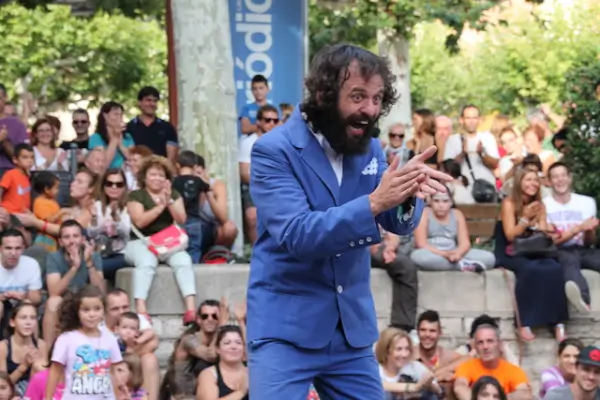 Antuán de la Cream, un clown con vestuario colorido y expresión divertida, interactuando con el público en un escenario.
